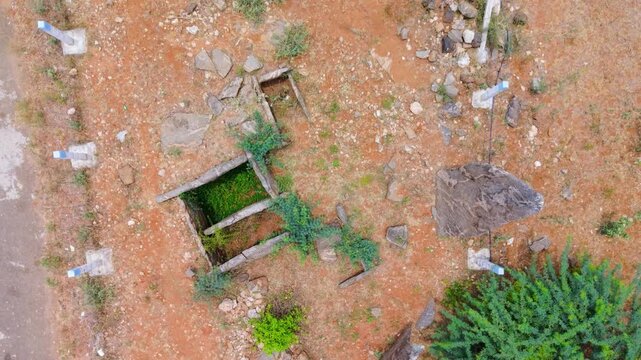 Cinematic top view of ancient megalithic burial site at Kodumanal, Tamil Nadu, India, with menhir standing stones, stone cist graves and red laterite earth revealing centuries-old history.