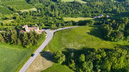 Fototapeta premium Aerial View of Winding Road and Historic Church in Piedmont Countryside
