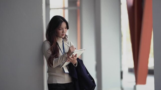 Business woman takes notes on paper notebook outdoors in city