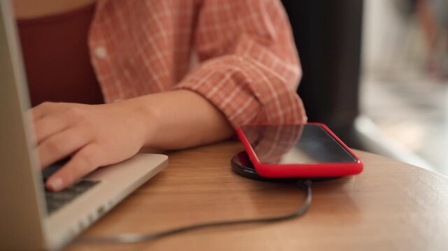 Wireless charger concept, smartphone with charging pad in modern office.