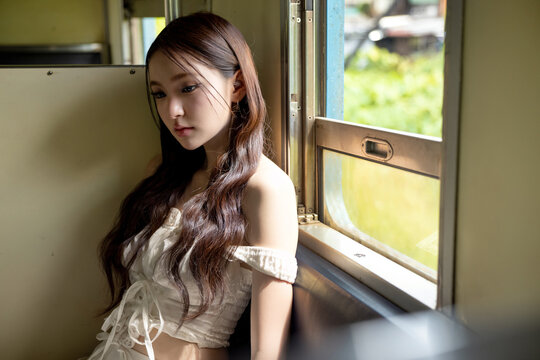 Social media trend in Thailand, Portrait of a stylish young Asian woman on a vintage train. Seated by the window, soft natural light creates a beautiful and timeless aesthetic.