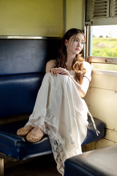 Social media trend in Thailand, Portrait of a stylish young Asian woman on a vintage train. Seated by the window, soft natural light creates a beautiful and timeless aesthetic.