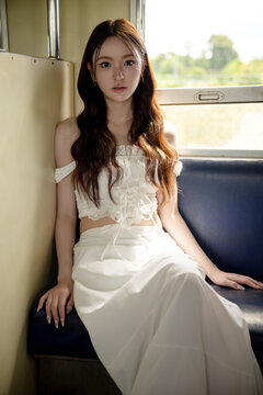 Social media trend in Thailand, Portrait of a stylish young Asian woman on a vintage train. Seated by the window, soft natural light creates a beautiful and timeless aesthetic.