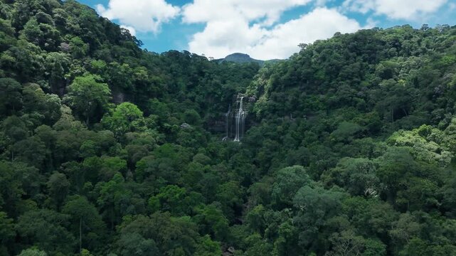  Drone forward flight to waterfall in deep green forest, aerial top-down view, National Park Laos PDR
