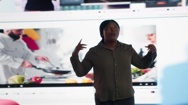 Woman engages with a digital video wall filled with online media, highlighting social media feedback, online engagement and modern video consumption in an immersive technology setting.