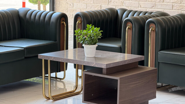 Modern hotel lobby with elegant black leather sofas, marble coffee table and contemporary interior design. Luxury hospitality lounge for guests in a premium resort or boutique hotel.