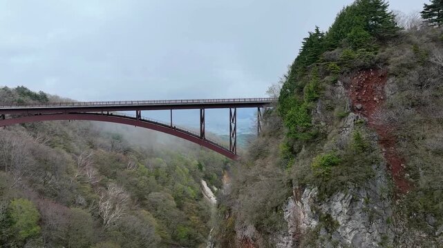 Close-Up Aerial Drone Shot of Fudosawa Steel Arch Bridge Structure with Spring Greenery, Fukushima