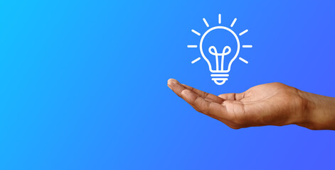 A hand presenting a light bulb icon against a blue background, symbolizing the generation of a new idea or business solution © susral