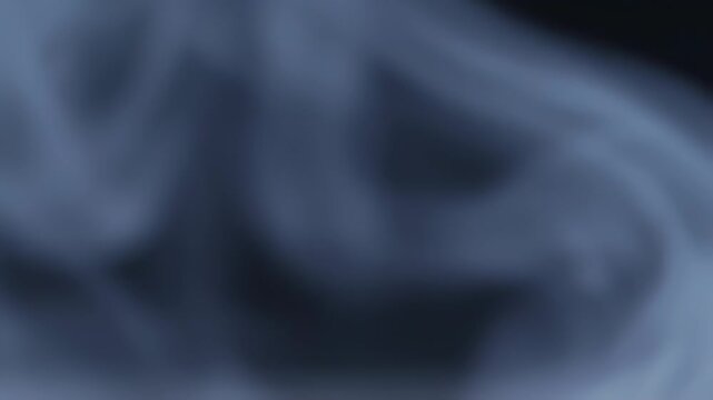 Smoke swirling in dark space.