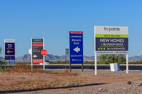 Residential subdivision entrance signs advertising new homes for sale, representing suburban housing development, residential marketing, and expanding real estate communities