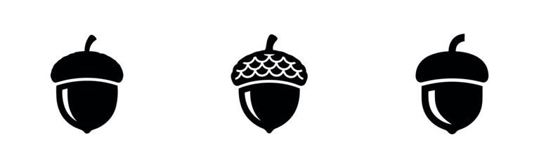 Collection of black acorn silhouettes with caps, symbolizing nature, growth, autumn, and forest elements. © Lili