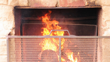 Obraz premium Close Up View of Fire Burning in a Rustic Brick Fireplace
