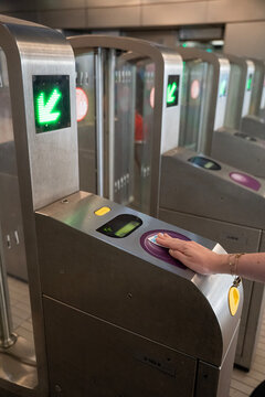 osoba skanująca kartę na bramce przy wejściu do metra