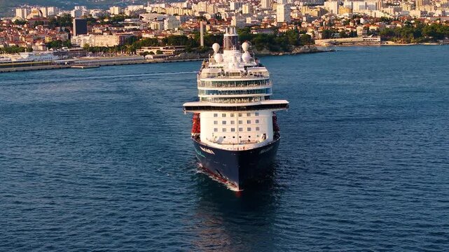 Cruise ship enters harbor at Mediterranean destination during summer vacation journey