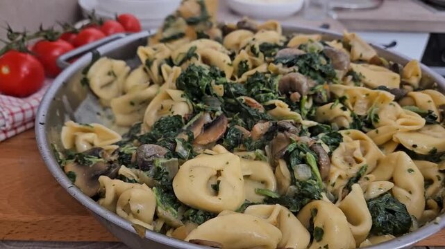 Chef cooking creamy tortellini pasta in a rustic kitchen with fresh vegetable ingredients