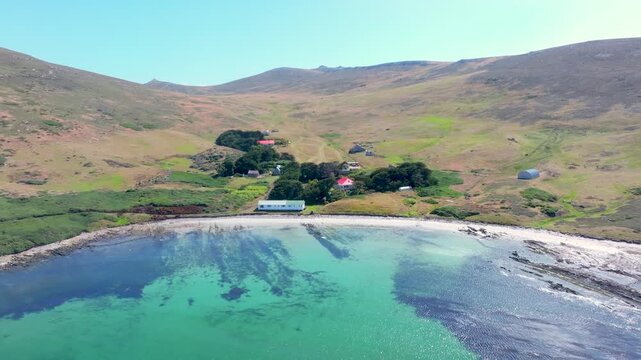 Wide Aerial Shot of Sheltered Beach, Houses and Rolling Island Hills