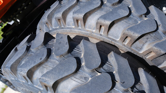 Close-up of a tractor tire on a construction site. Heavy-duty tires.