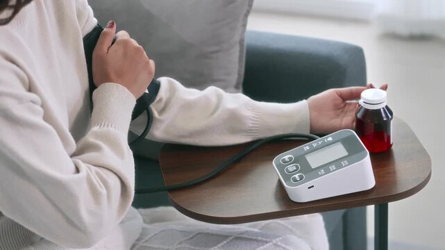 Female  monitoring blood pressure at home