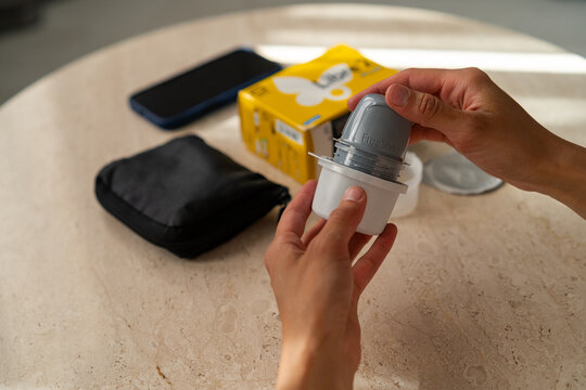 Minsk, Belarus - June 23, 2026: Cropped shot of human hands connecting a FreeStyle Libre glucose sensor applicator with its container on a table with a product box and a smartphone