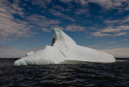 Majestic iceberg adrift in the deep blue sea on sunny summer day