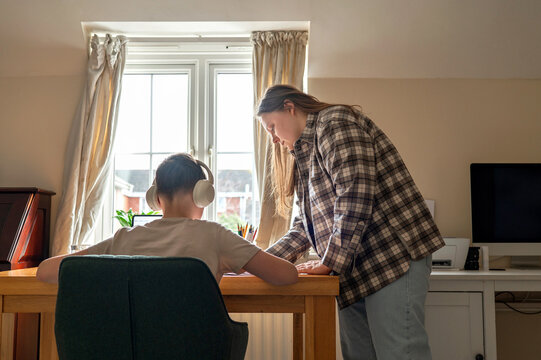 Mother helping son with homework during online learning at home