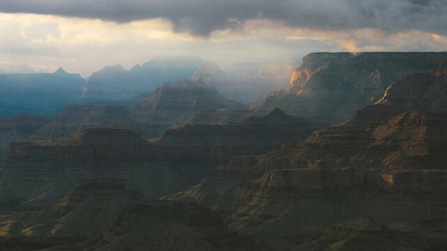Sunlight filters through clouds over the Grand Canyon