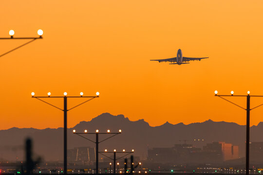 Airplane departs over mountains during golden hour