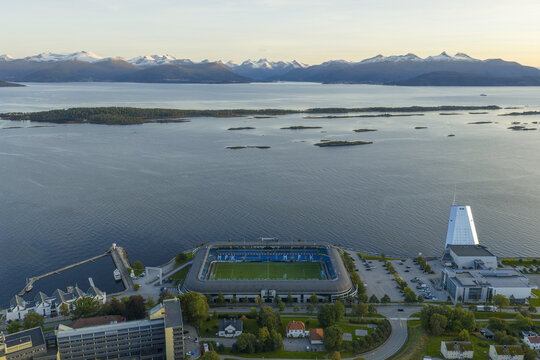 Aerial view of Aker Stadium, the home ground of Molde FK, situated on the waterfront with snow-capped mountains in the background in Molde, More og Romsdal, Norway.