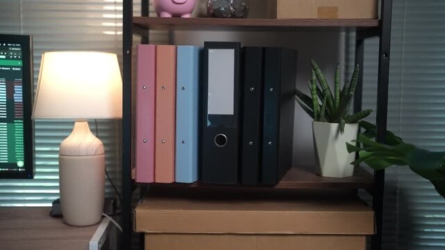 High-quality close-up video of organized office binders and business records stored on a shelf. Suitable for document management, office administration, corporate filing systems, workplace organizatio