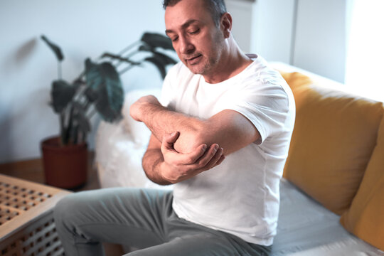 Man with elbow pain at home.