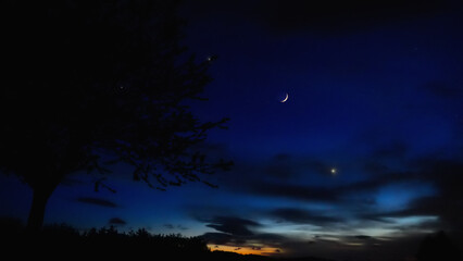 Fototapeta premium Crescent Moon, planet conjunction and landscape scenery silhouettes.