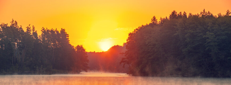 Magical sunrise over the lake with a beautiful reflection on the water. Serene lake in the early morning. Nature landscape