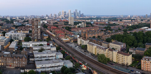 Obraz premium Aerial Panorama of London Railway Tracks, Shadwell Station, and Canary Wharf Skyline
