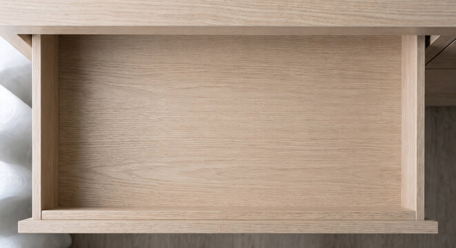 Top down view of an open empty light wood drawer with copy space
