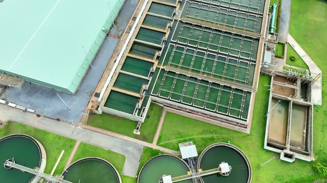 Aerial drone view shows a drinking water production plant with settling tanks and process channels, reflecting water purification technology, urban service networks, and sustainability planning. 4k.
