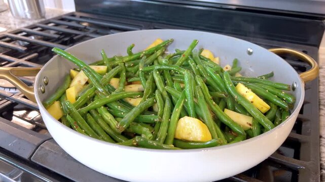 Pan of sauteed green beans and squash on gas stove