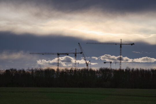 Majestic Silhouettes of Construction Cranes Against a Dramatic Stormy Sky
