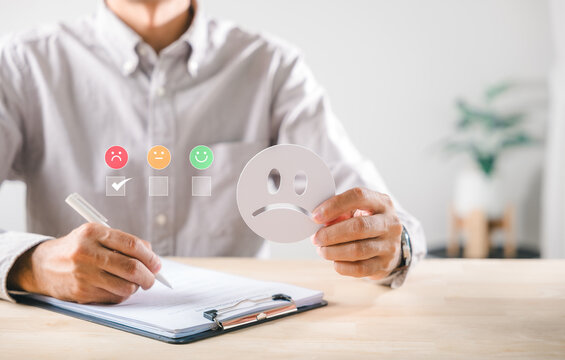 Survey feedback shows customer satisfaction review indicating low service quality, person selects sad face icon, records negative experience on official check form, evaluates overall quality