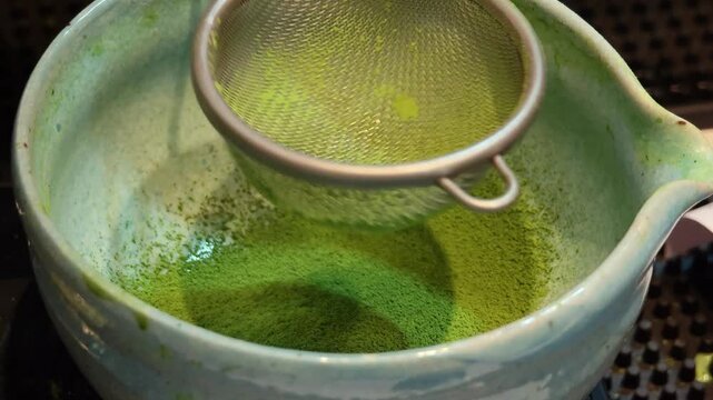 Matcha green tea powder on a net strainer