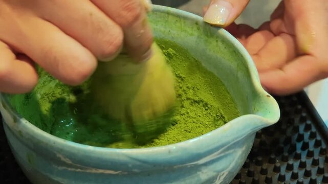 Stirring a pure matcha drink at a coffee shop.	