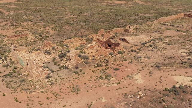 4K UHD drone video: an unknown abandoned stone structure slowly decays in the Arizona desert. Crumbling masonry and a collapsed vaulted roof hint at an early 1900s settlement left to the wilderness.