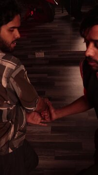 Close up of two men struggling over handgun during intense fictional confrontation