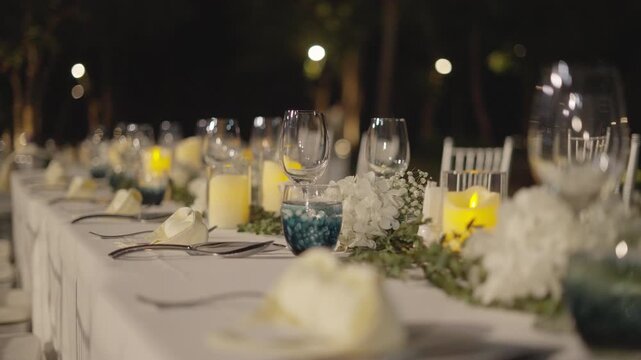 Wedding table with candles dinner. Close up setting table row chair flower reception party.
