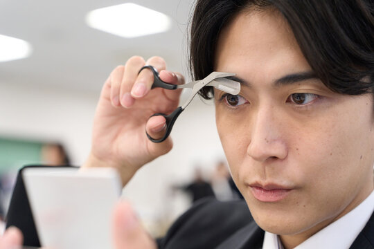 眉毛の手入れをするアジア人ビジネスマン