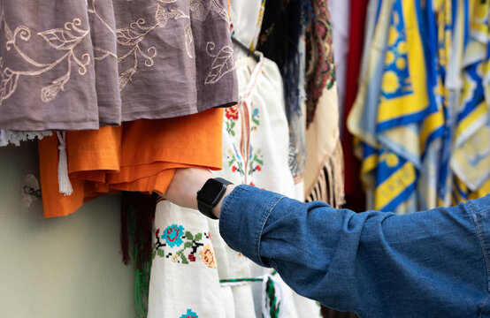 Shopper Examining Traditional Ukrainian Embroidered Clothing