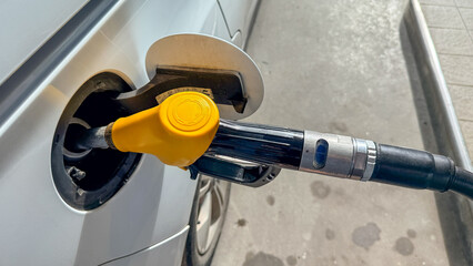 Yellow fuel pump nozzle at a service station in daylight suitable for automotive editorial and energy marketing, 5 May 2026 Subitica, Serbia © fotoworld