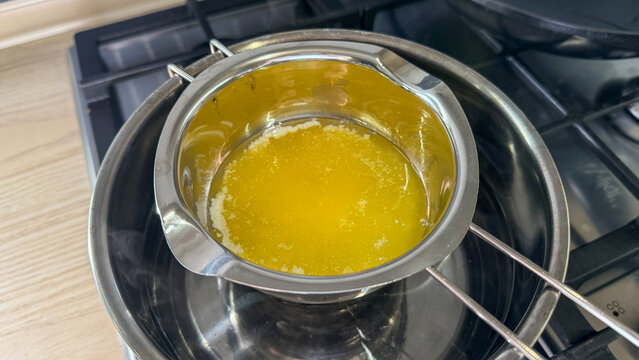 Melted butter in a double boiler on a gas stove warm light ideal for recipe blog food photography cooking tutorial and social posts, 5 May 2026 Subitica, Serbia