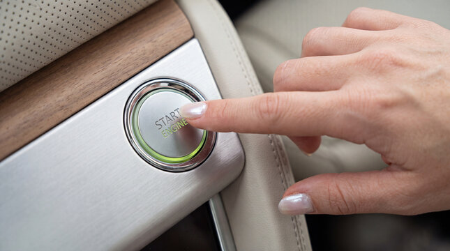 Start the engine from the START ENGINE button in the car. A woman presses the ignition button for a car ride