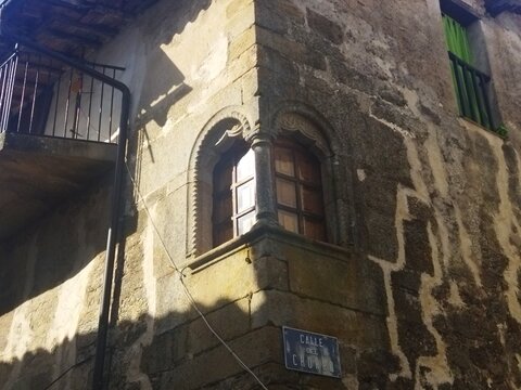 Ventana g&oacute;tica en esquina con columna central en la Calle del Chorro de Hoyos, Sierra de Gata, C&aacute;ceres, Espa&ntilde;a.