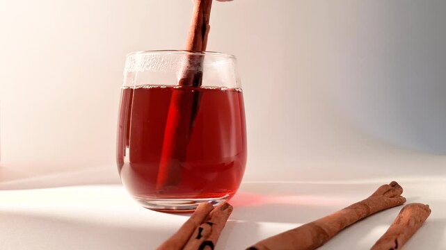 Warm herbal tea steeps with a cinnamon stick in a clear glass creating a cozy and aromatic beverage perfect for relaxation or a cold day